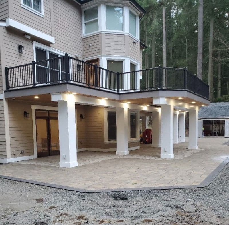 Modern house exterior featuring a balcony, patio, and landscaped surroundings. Ideal for outdoor living.